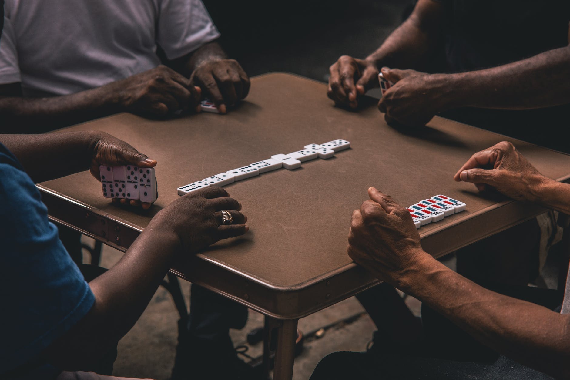 four people playing dominoes