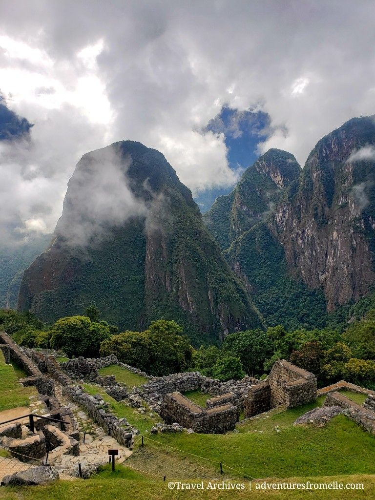 Machu Picchu in foreground, with Huayna Picchu Peak covered by clouds in background