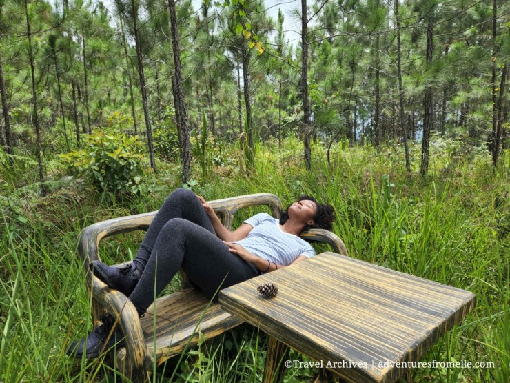 Girl lying on bench in forest
